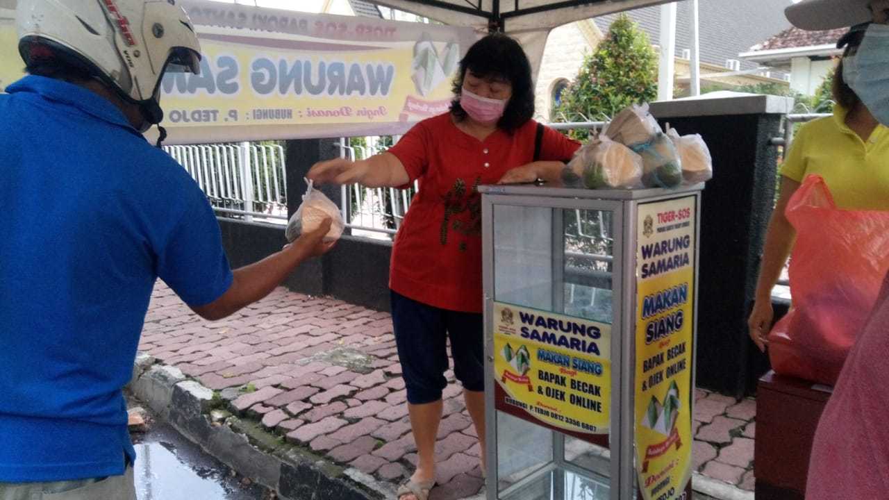 pengendara sepeda motor ambil nasi bungkus